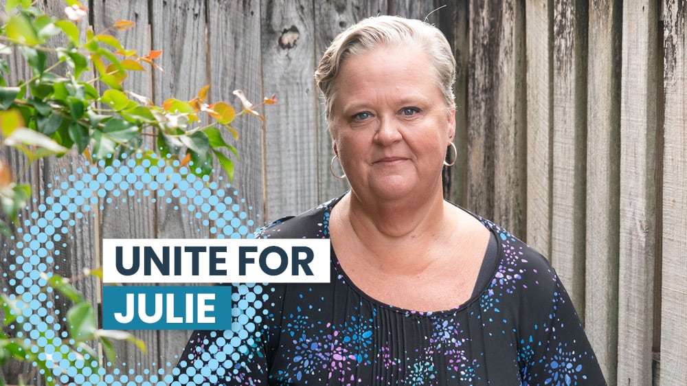 Unite for Julie, in the back garden next to a tree and wooden fence