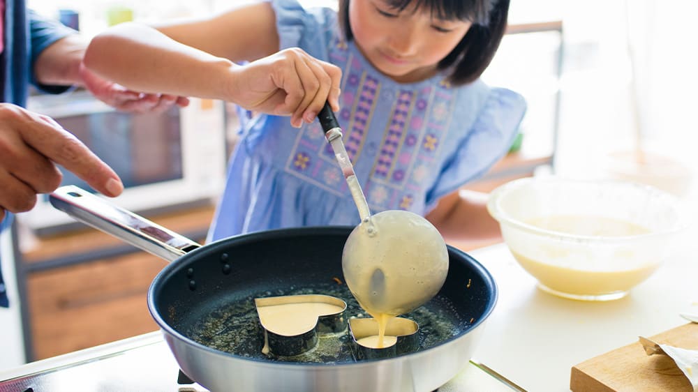 girl making heart shaped pancakes