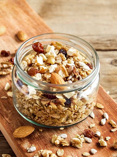 Muesli in a jar, sitting on a wooden cutting board