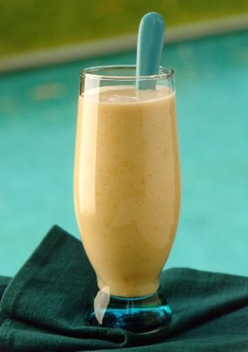 Almond smoothie in glass cup with blue spoon