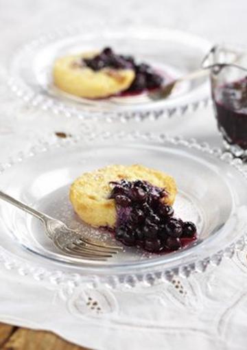 Ricotta Pies topped with blueberry coulis on a glass plates with a fork