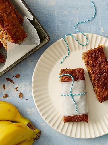 Banana Oat Bars on a plate wrapped in tissue and blue string