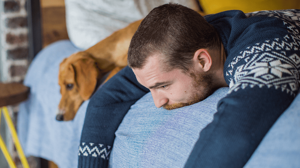 beat the winter blues, man lethargic on bed with dog