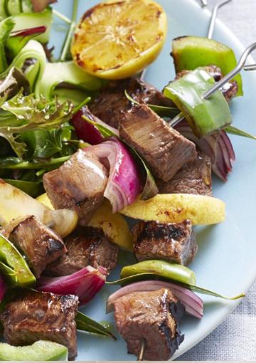 beef kebabs with salad and roasted lemon slices