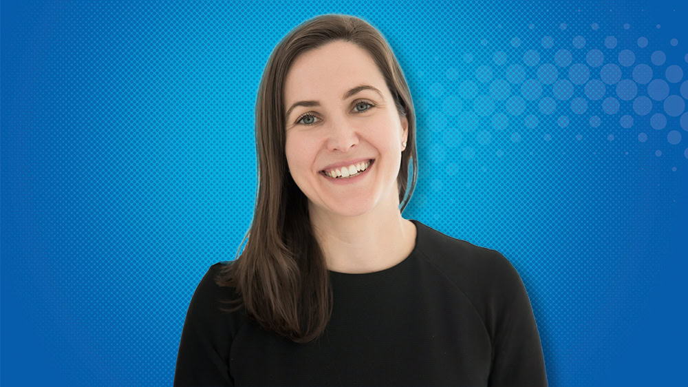 Bernadette Prentince smiles against a blue background.