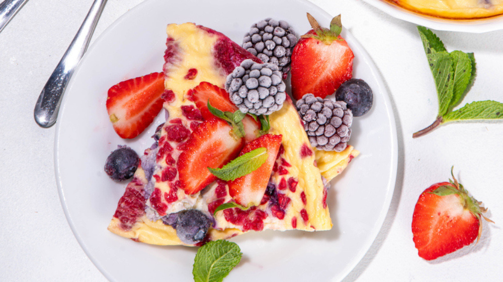 Colorful berry-topped creamy dessert slice