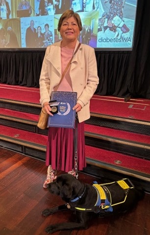 Colleen shows her Kellion with her guidedog at her feet.