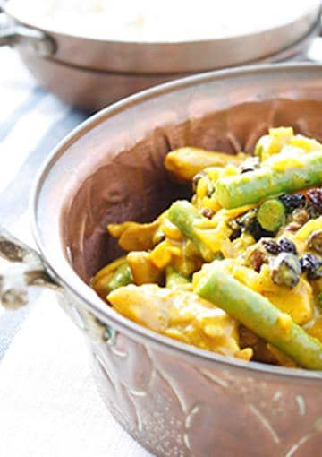 curry chicken with vegetables in a copper pot