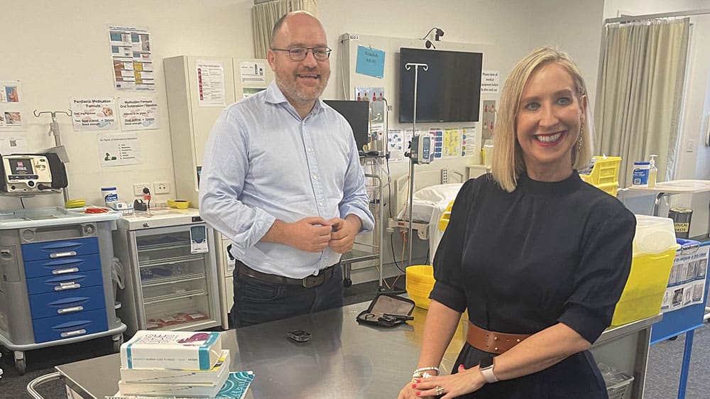 Dr Steven James checking his blood glucose levels after his presentation with the 2024 Charles Campbell Coghlan OAM Emerging Researcher Award by Diabetes Australia Group CEO Justine Cain