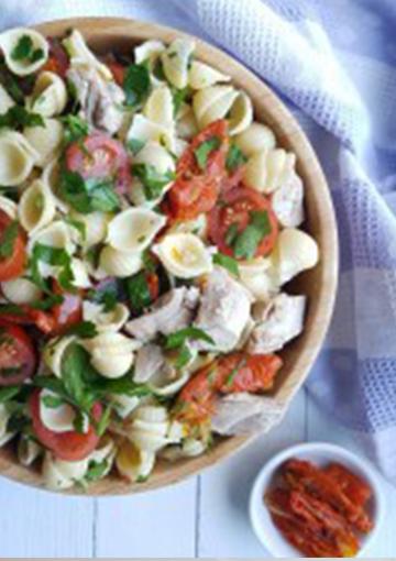 Chicken and pasta salad topped with parsley and tomatoes