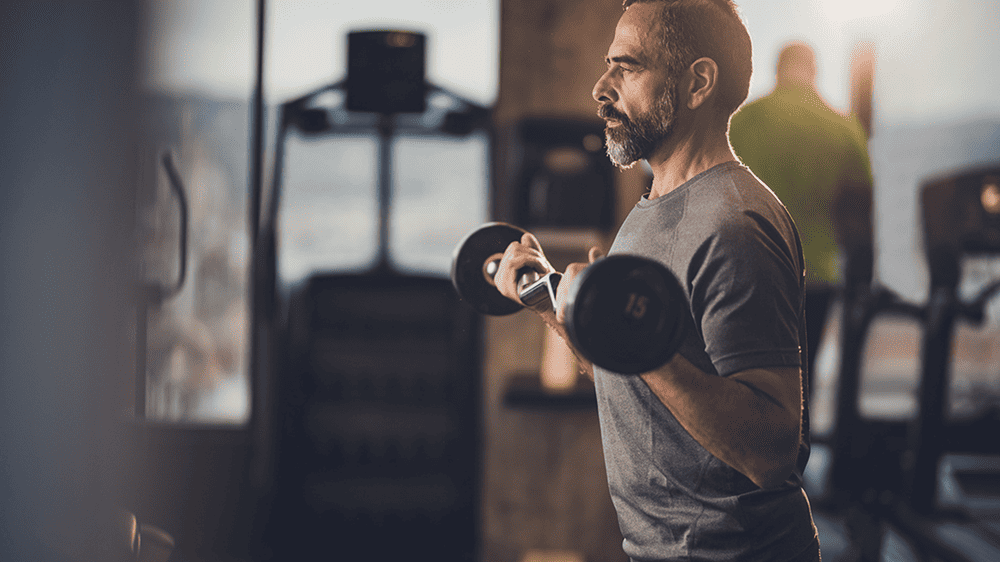 man lifting weights using strength exercise to work the whole body