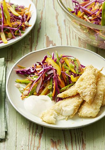 fish fingers with slaw and aioli on a white plate