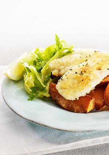 fish and chips with a spinach salad and lemon wedge