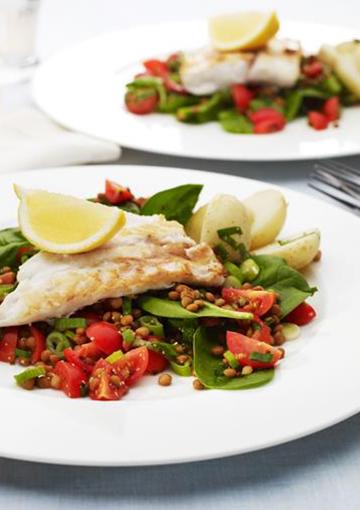 fish with lentil spinach salad and a slice of lemon