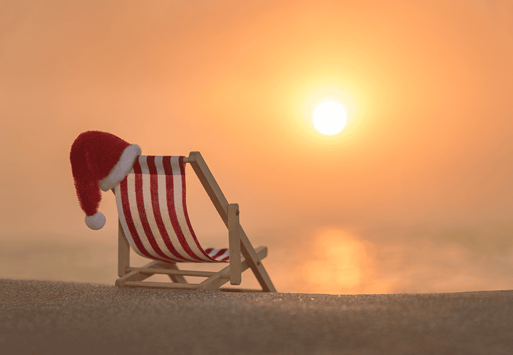 santa hat on the back of an empty deckchair on a hot day at beach