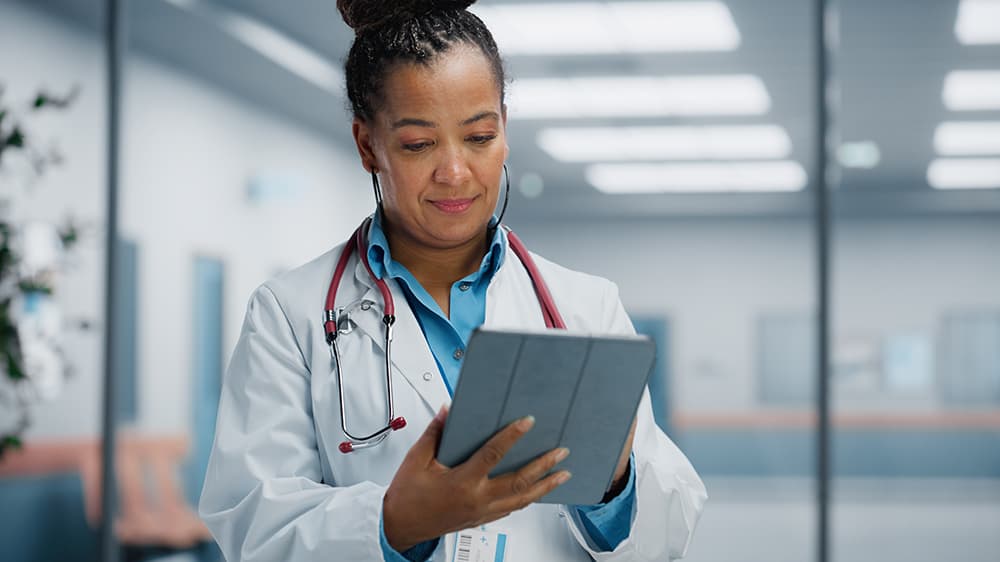 Health professional accessing patient information on a tablet device 