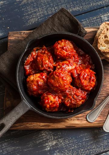 meatballs in a tomato sauce in a black skillet