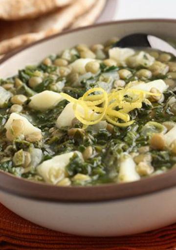 Soup with potatoes and spinach topped with lemon zest