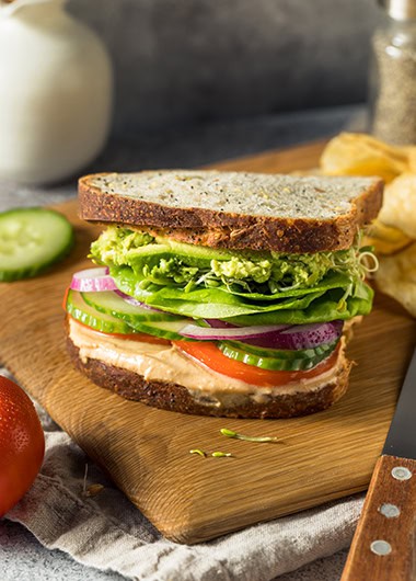 Hummus sandwich on cutting board