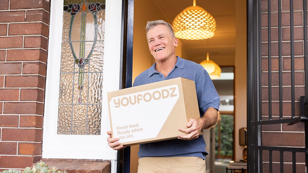 Man carrying a YouFoodz delivery