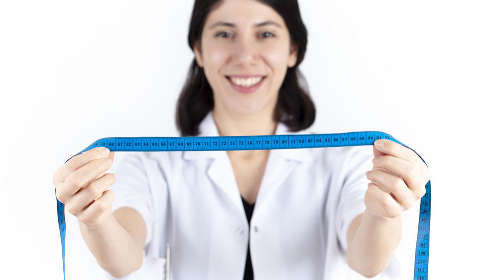 tape measure in the hands of the nutritionist. ideal body measurements concept. healthy diet and diet. isolated in white background.