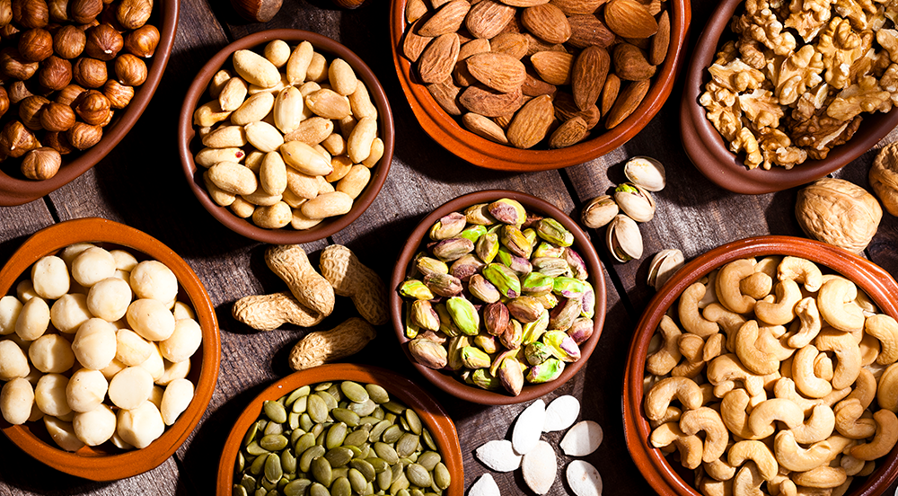 overhead shot of raw, unsalted nuts in different sized bowls