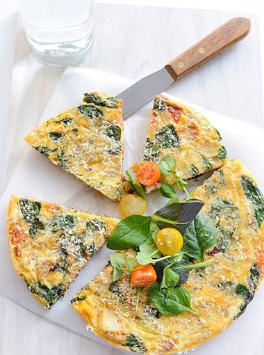 Potato and Salmon Frittata topped with baby spinach and cherry tomatoes
