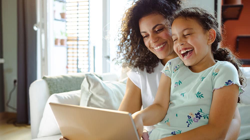 Parent and child using laptop for an online event