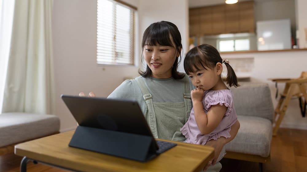 Parent using a laptop with child 