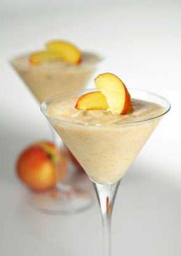 Mousse topped with peach slices in glass cocktail glasses