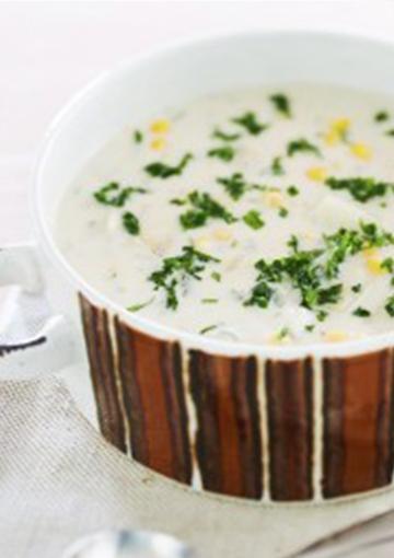 Corn chowder with potato garnished with parsley and green onions