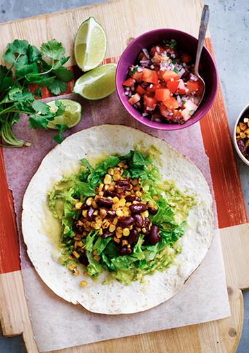 Bean burrito with tomato salsa on a wooden slab