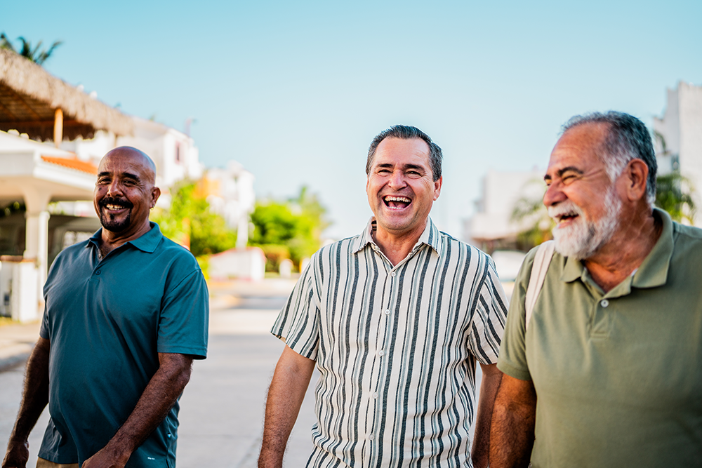 Three older men walking down the street laughing