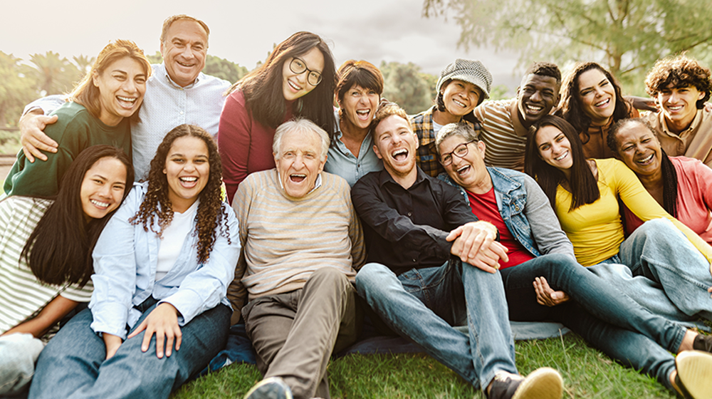 About 20 people of all ages smile at the camera in two rows.