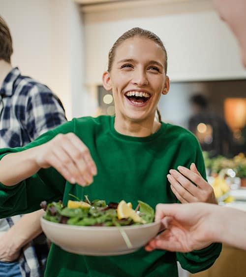 Woman smiling accepting a plate of food
