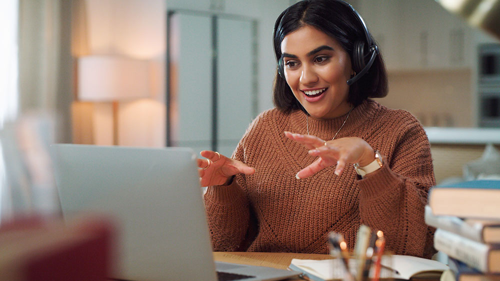Woman with a headset on speaking on a telehealth call
