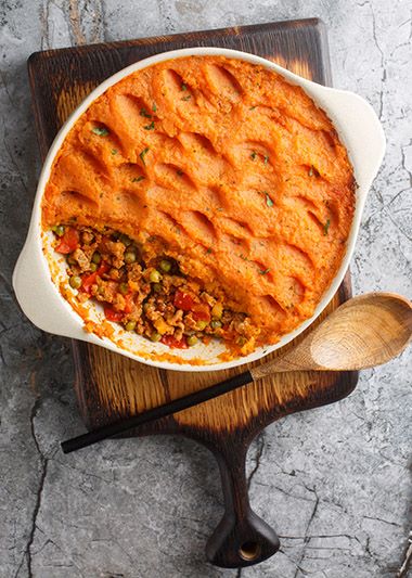 Shepherds' pie resting in serving platter on cutting board