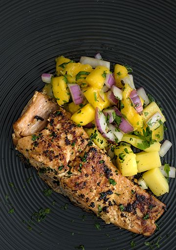 BBQ salmon with mango salsa on a plate, ready to eat