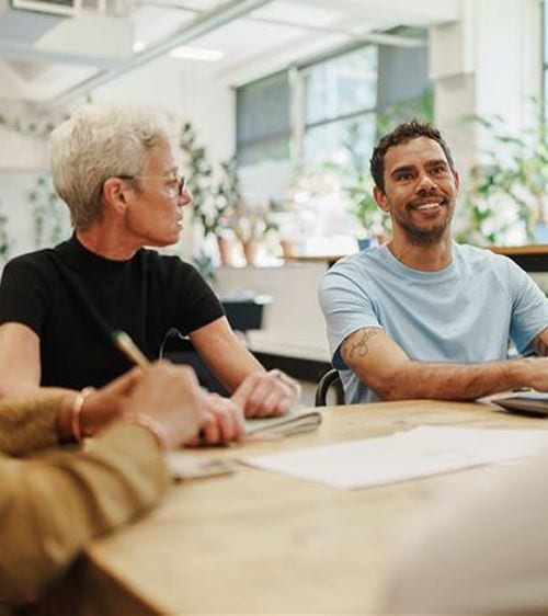 Group of people sitting at a table discussing topics
