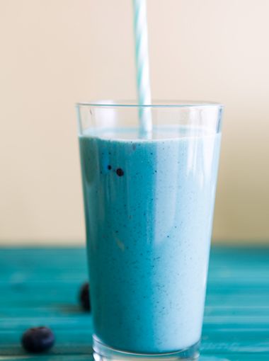 Blue smoothie in a glass, with a straw
