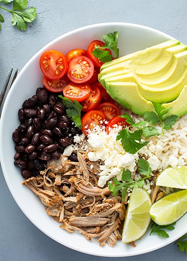 Pork carnitas bowl or burrito bowl with rice, tomatoes and avocado