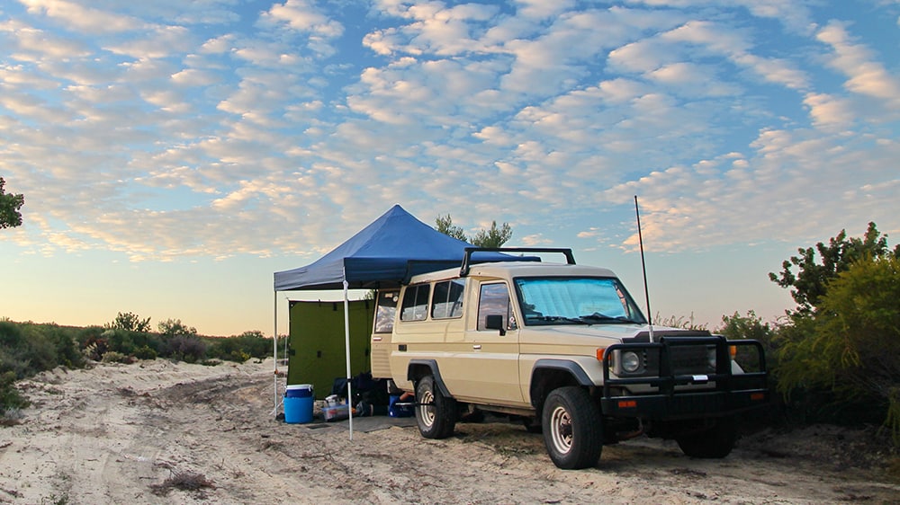 Off road in an beige SUV setting up camp