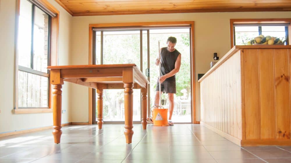 Young man cleaning dining room floor