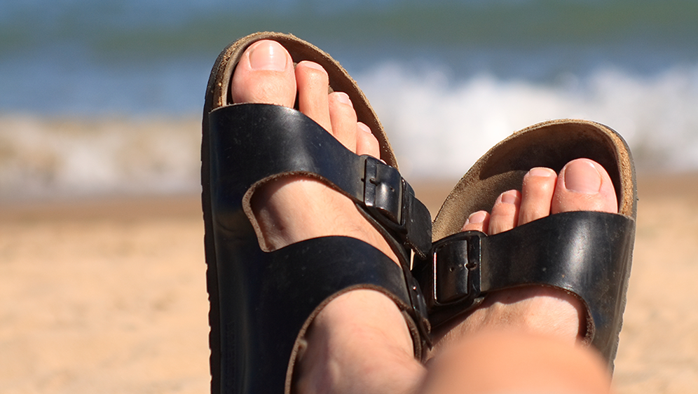 feet in sandals at the beach