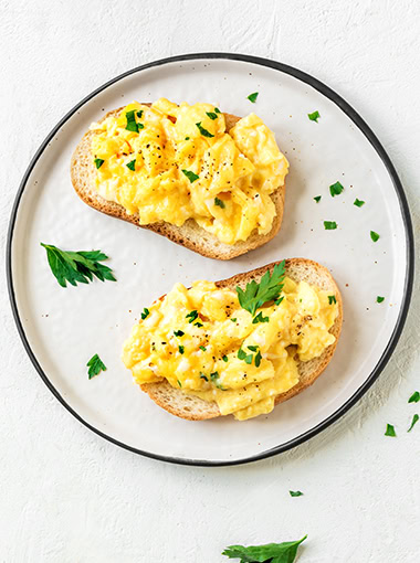 Scrambled Eggs on toasts for healthy breakfast or brunch