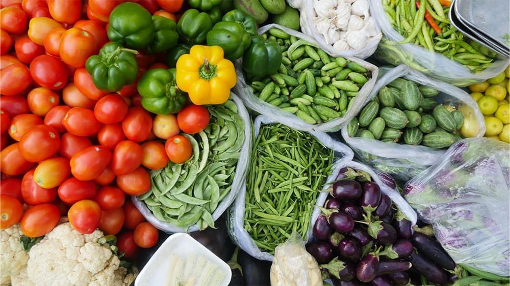 Fresh vegetables including tomatoes, beans, peas and eggplants