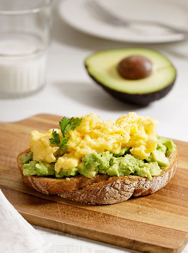 Avocado and eggs on toast, placed on a cutting board