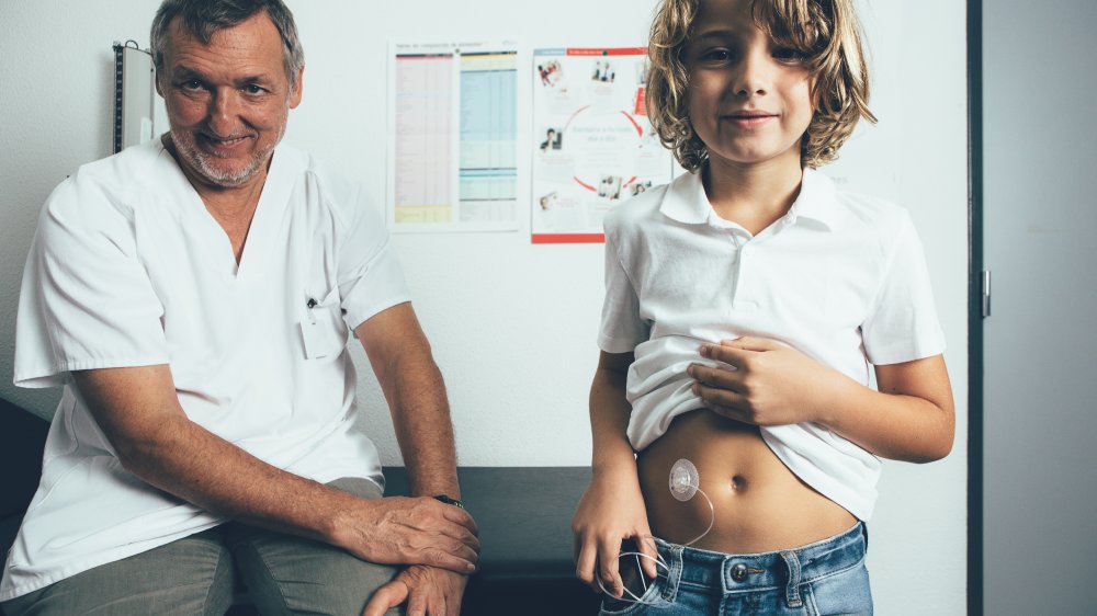 A young person with an insulin pump alongside an adult