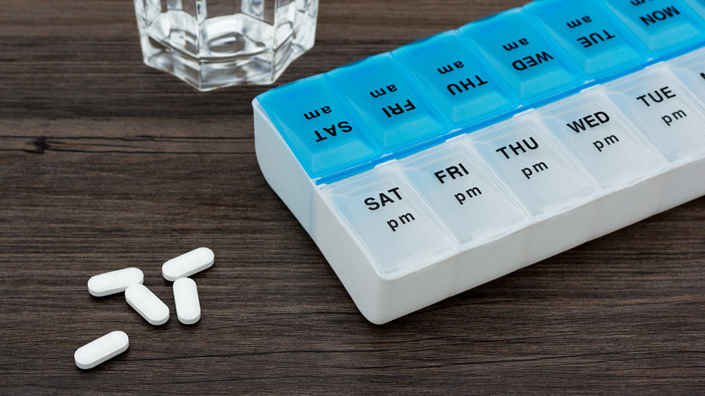 Tablet container with tablets and a glass of water