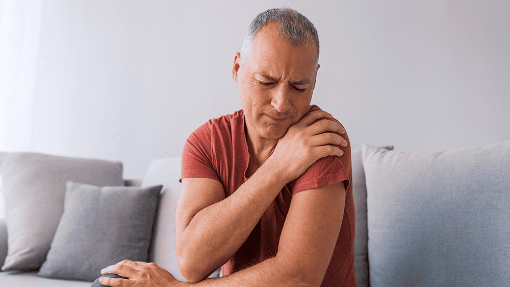 seated man with sore shoulder